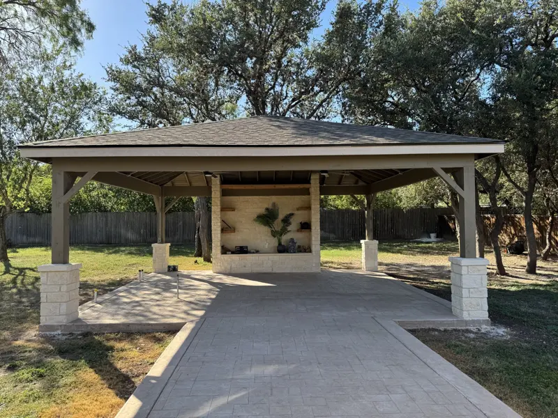 Hip-roof carport with stone columns and paver driveway