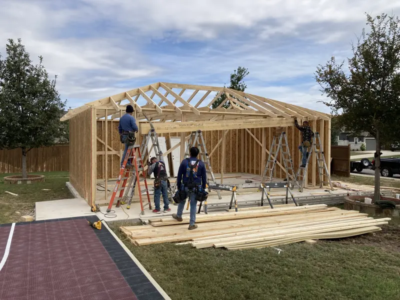 Crew setting roof trusses on a custom garage