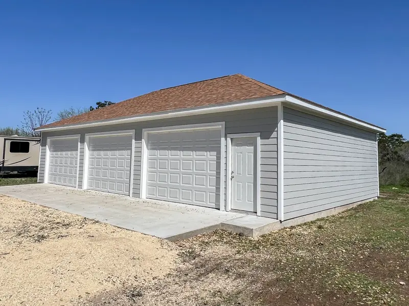Three-door gray detached garage with hip roof
