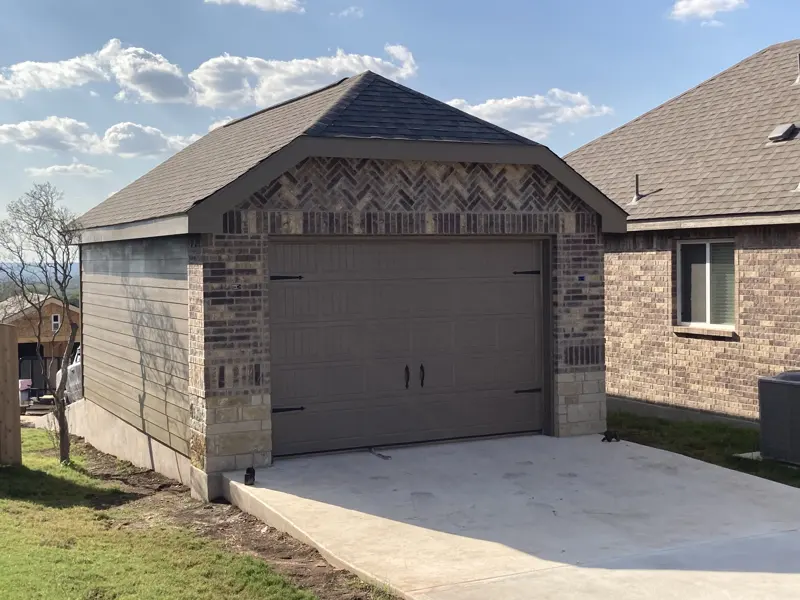 Garage with herringbone brick gable and oversized door
