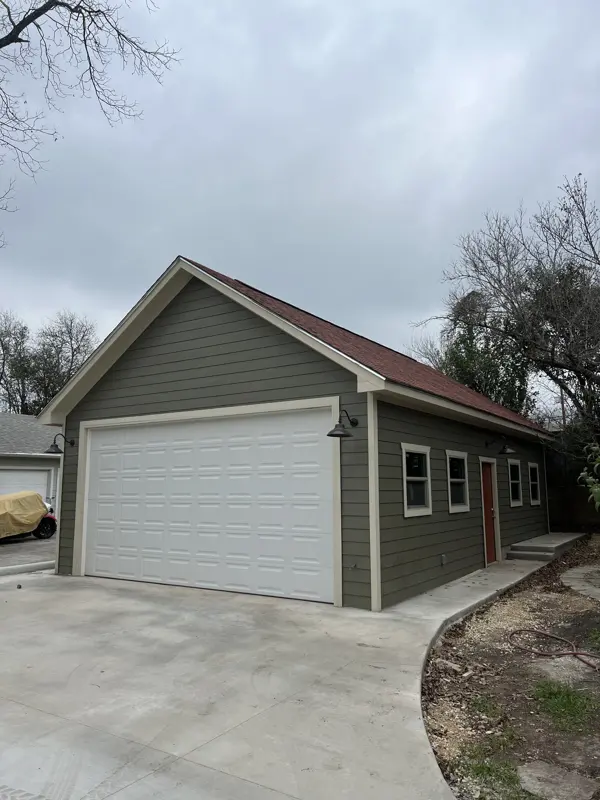 Sage green garage with extended concrete driveway
