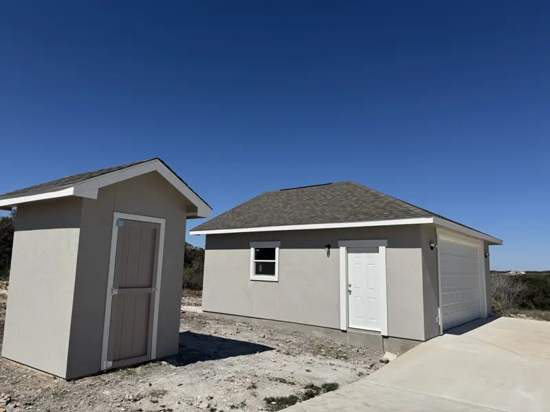 Detached two-car garage with matching storage shed