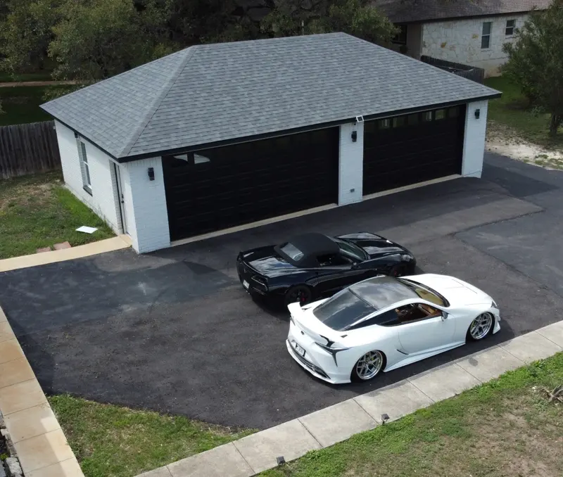 Aerial view of a white two-car detached garage with black doors