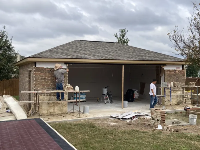 Masonry crew laying brick on a garage build