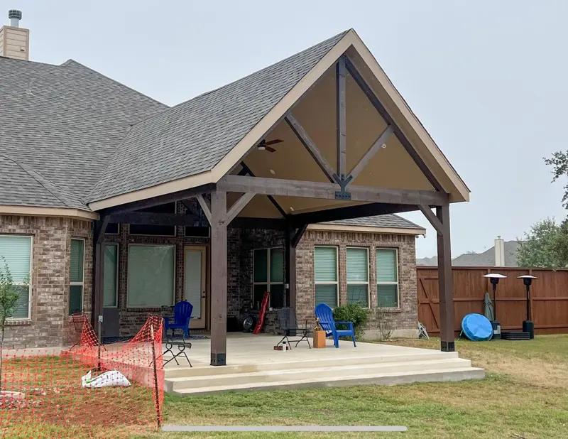 Cedar-post patio cover addition on a brick home